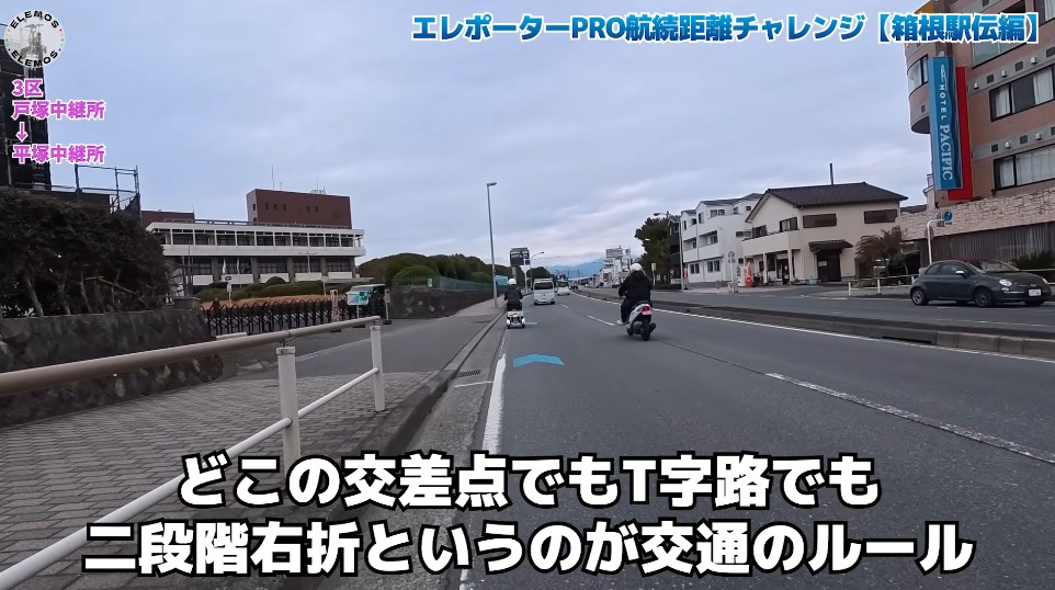 2026-05-04_171611 | ELEMOs Street scene in Japan with motorcycles on a multi-lane road; on-screen caption explains the rule of two-stage right turns at T-intersections.