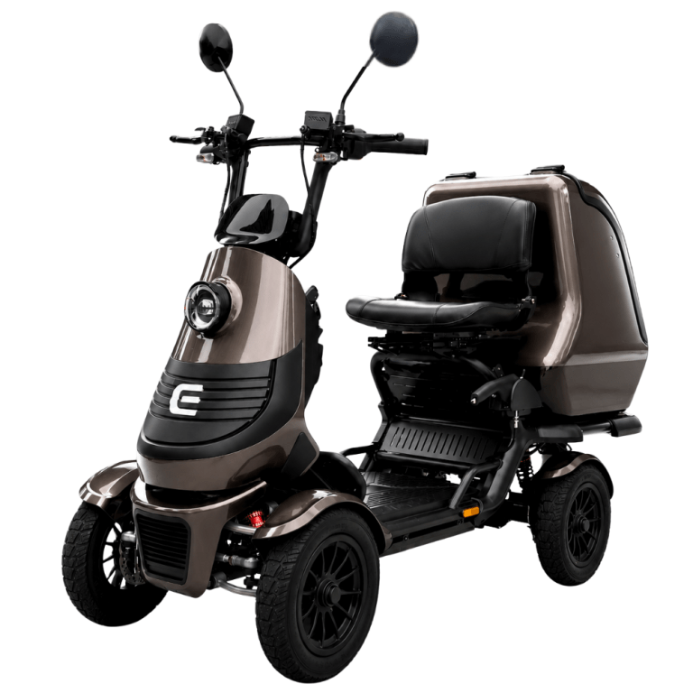 Three-wheeled mobility scooter with a taupe body, front headlight, and a large enclosed rear storage compartment behind the seat.
