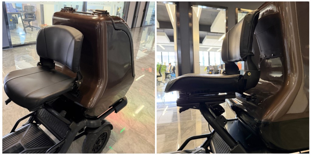 Brown mobility scooter on display, showing a padded black seat and backrest with a large rear storage box behind it, in a showroom.