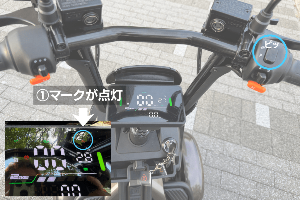 Cockpit view of a motorcycle with a digital speedometer reading 0 km/h, handlebars and controls visible; blue circle highlights a switch area on the right handlebar.