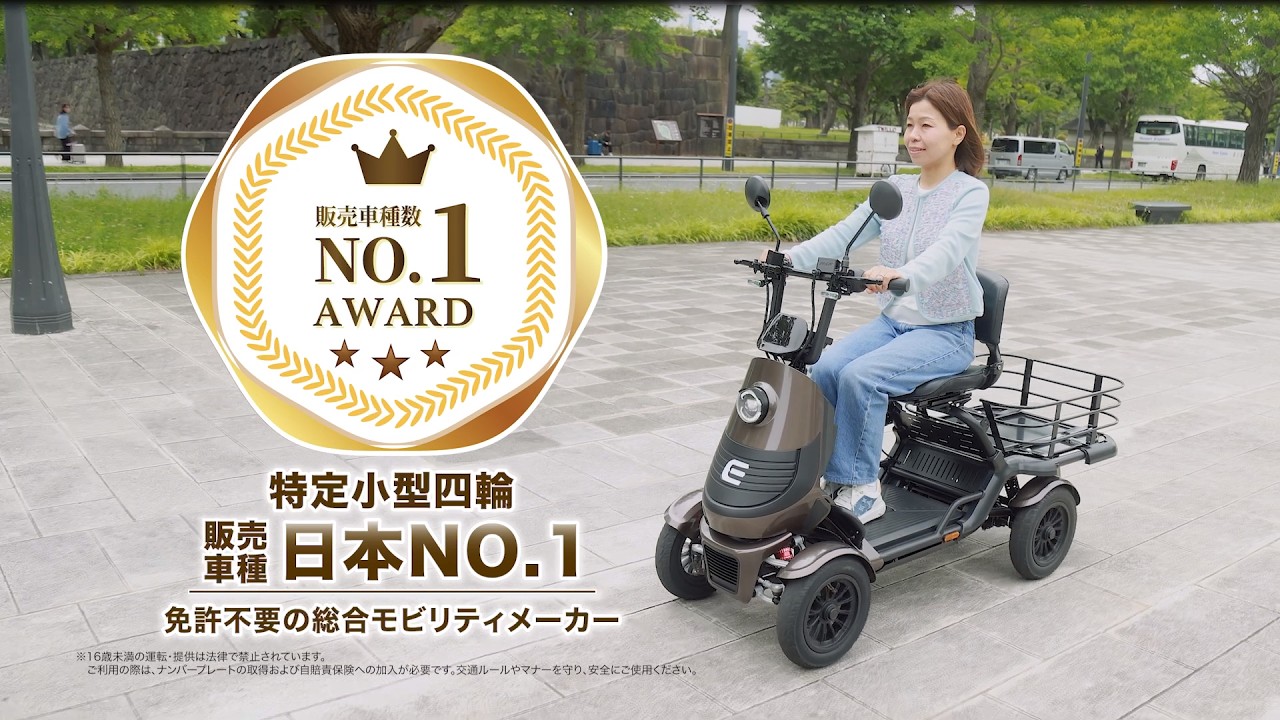 Woman rides a brown, four-wheeled mobility scooter outdoors next to a large NO.1 AWARD badge and Japanese text (promotional image).